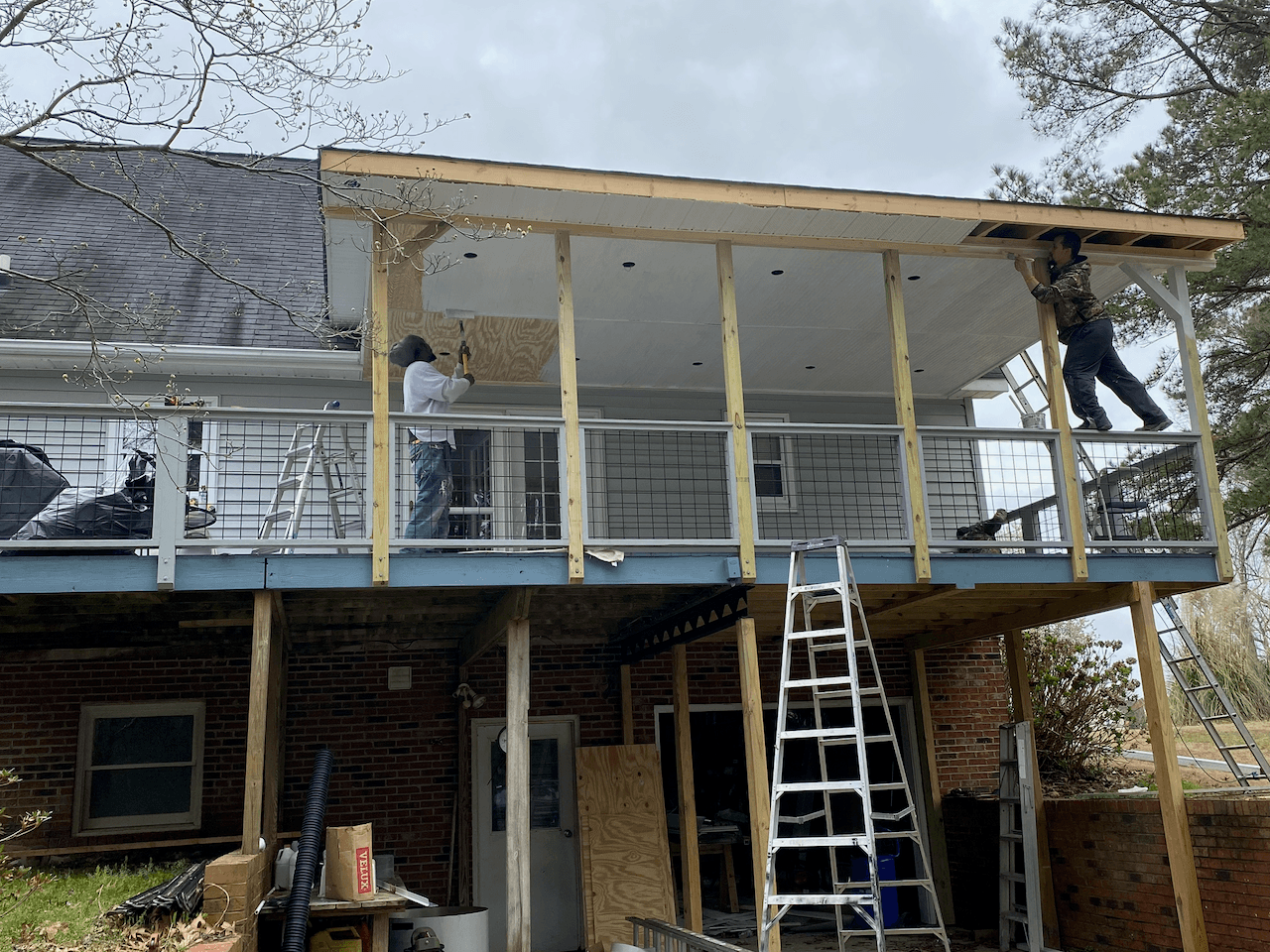 NCPS crew framing a new porch roof on the back of a brick home